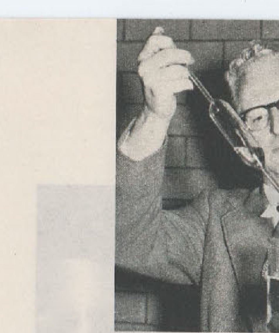 Man in glasses holding telescope or similar instrument