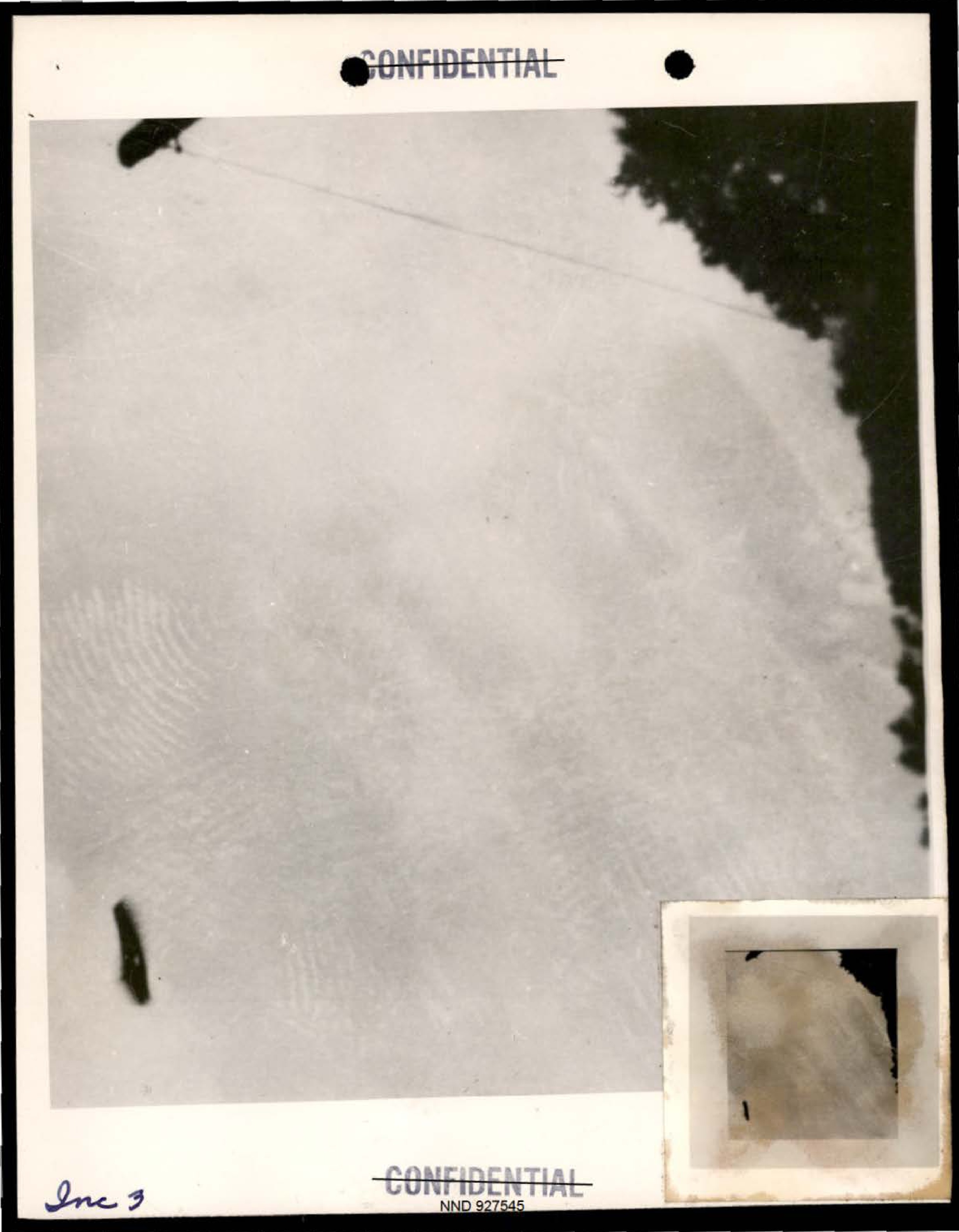 Photograph showing several dark objects and a fingerprint-like pattern.