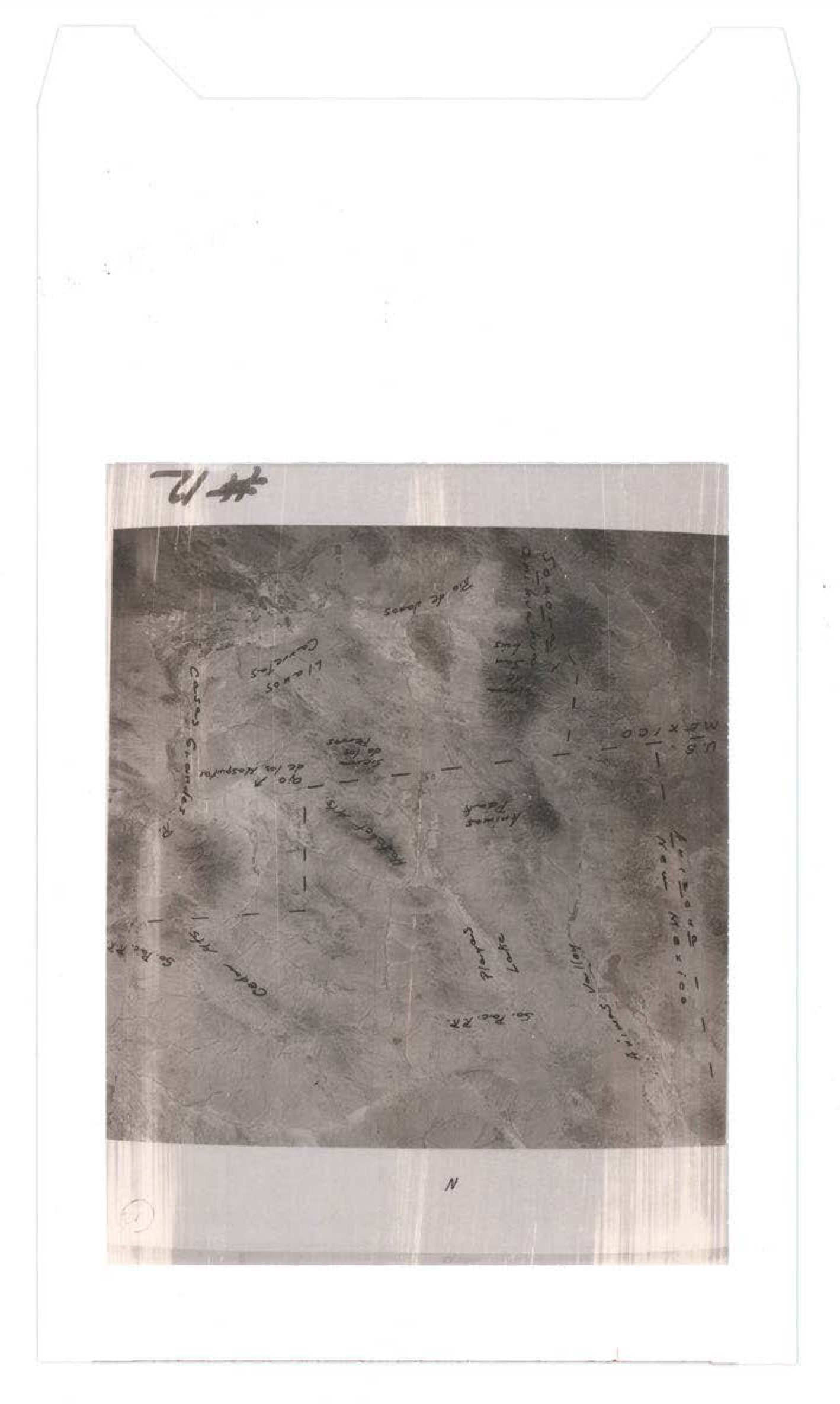 Heavily degraded or damaged photograph with handwritten annotations overlaid; image quality poor with significant deterioration making details illegible