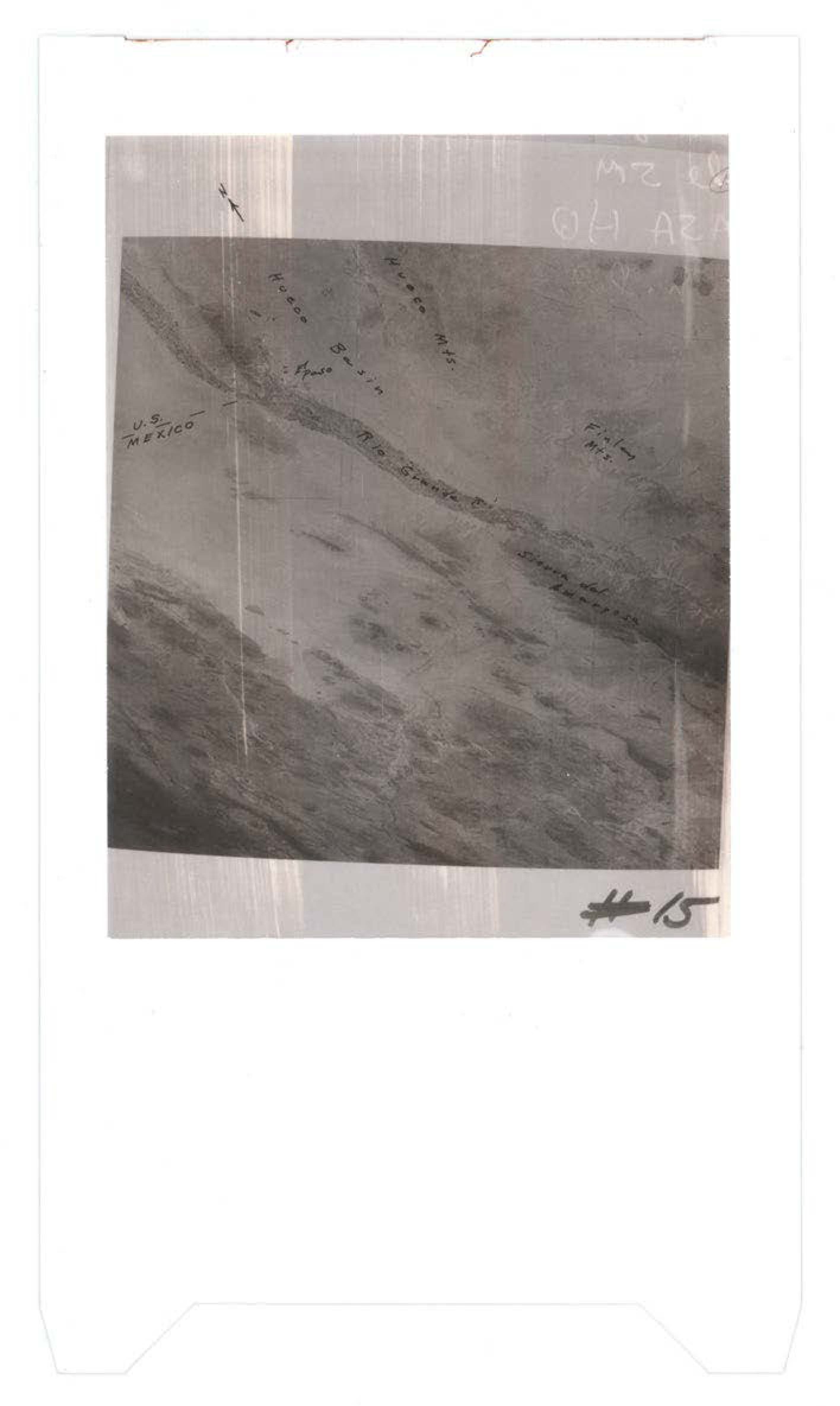 Aerial photograph showing terrain with border markings between U.S. and Mexico, with handwritten annotations and dotted lines indicating boundaries or features