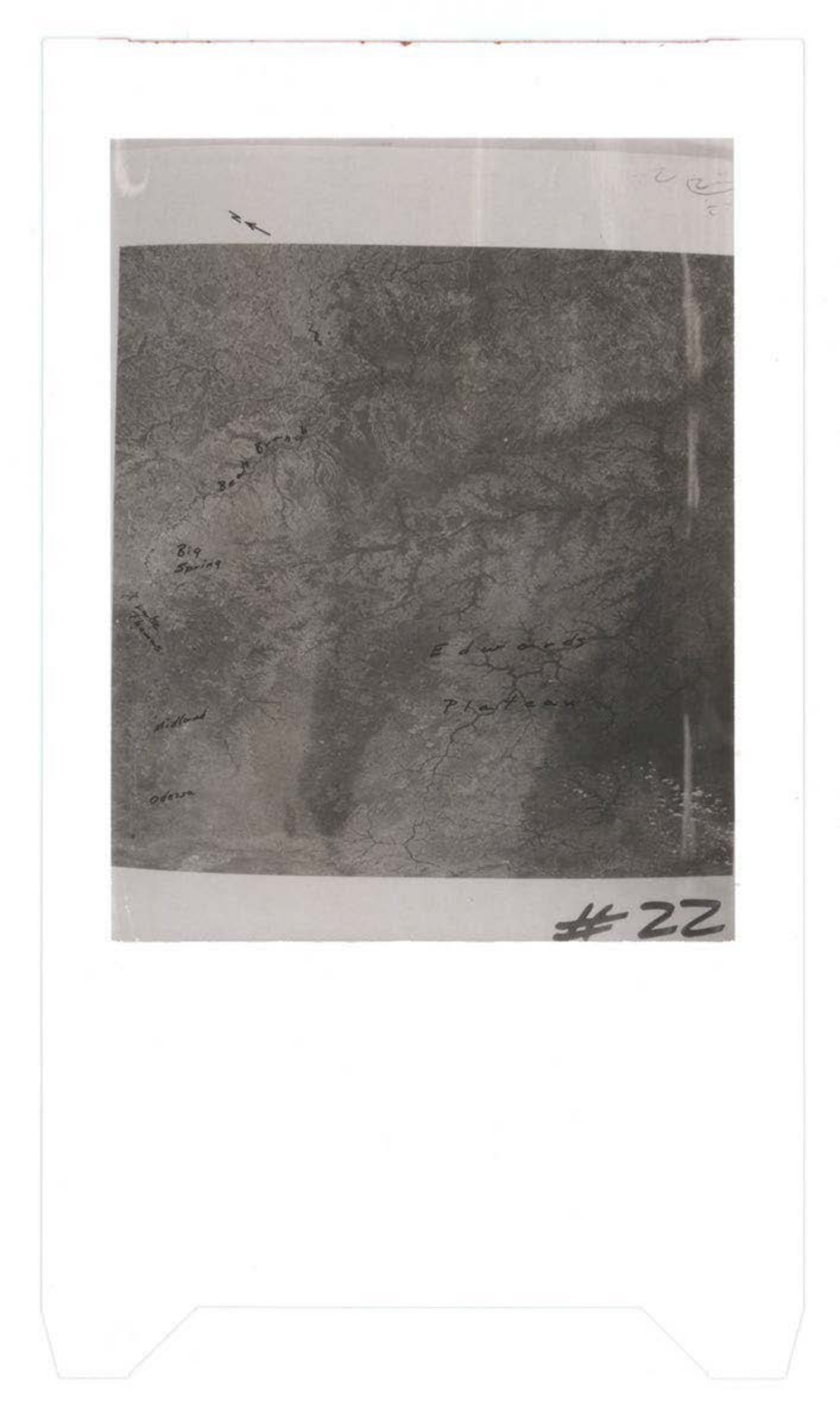Grainy black and white photograph showing textured surface or terrain with handwritten notations and markings, labeled #22