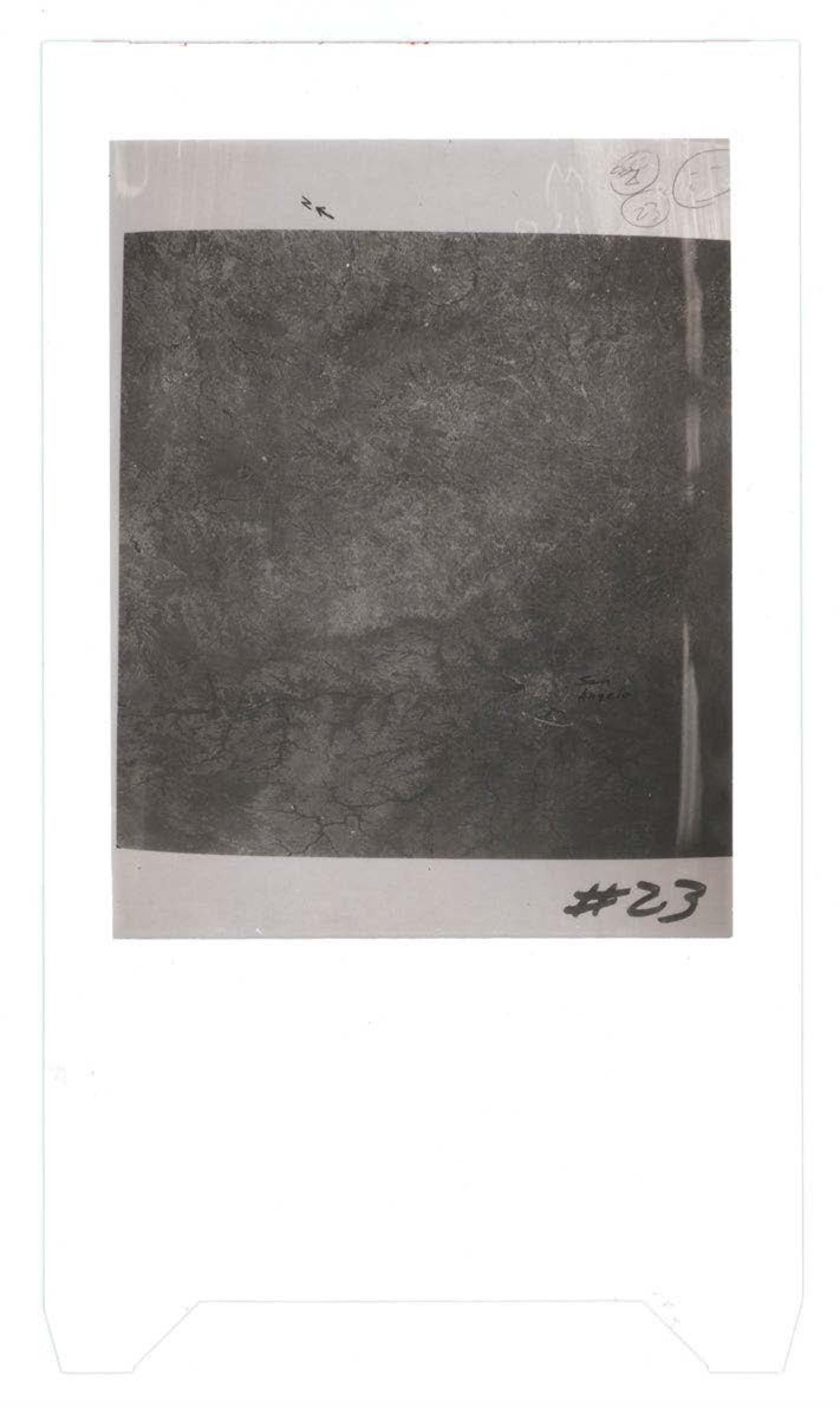 Grainy black and white photograph showing textured surface or terrain, possibly aerial or ground-level view of debris field or landscape