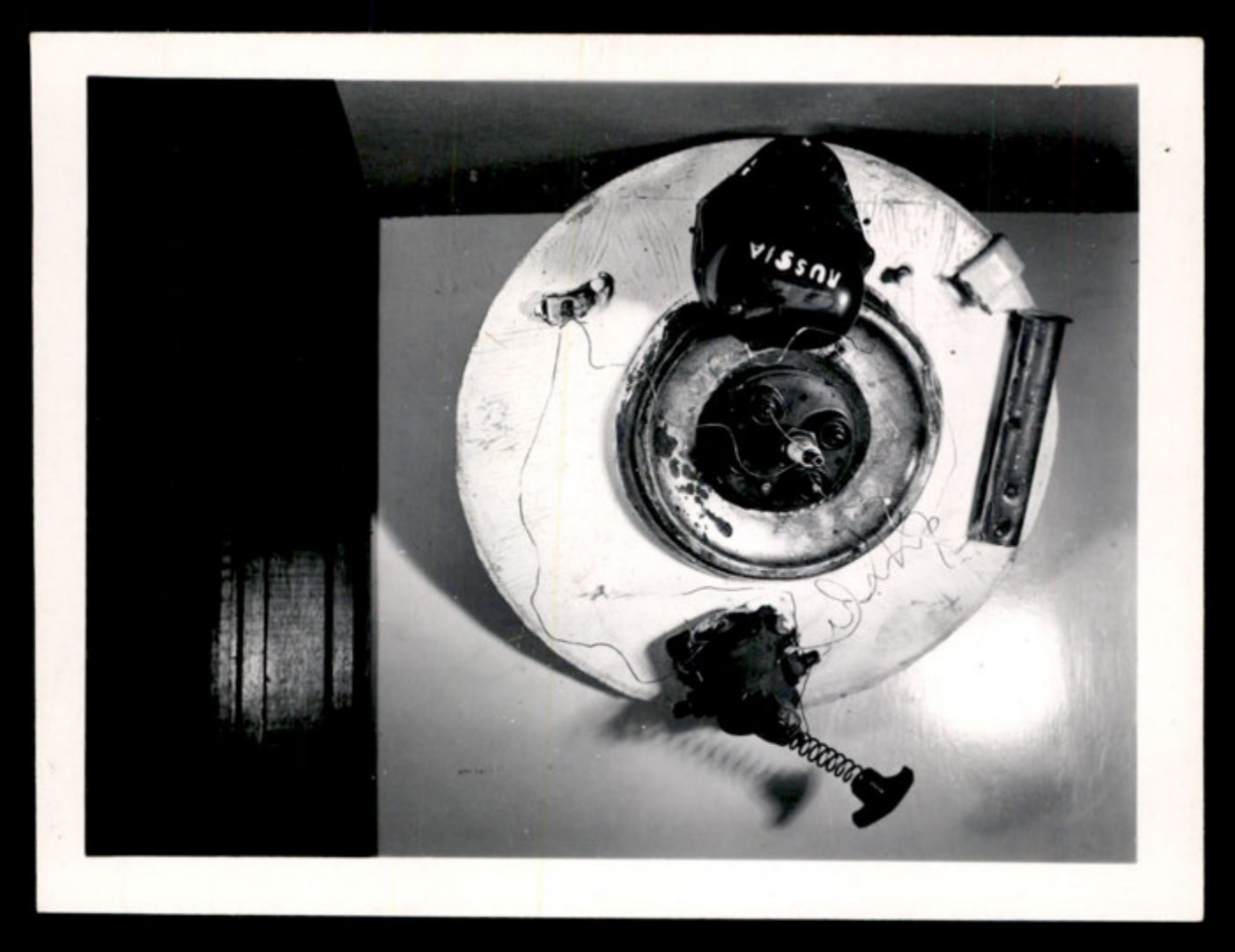 Overhead view of a constructed disc-shaped object with electronic components, one labeled 'RUSSIA'.