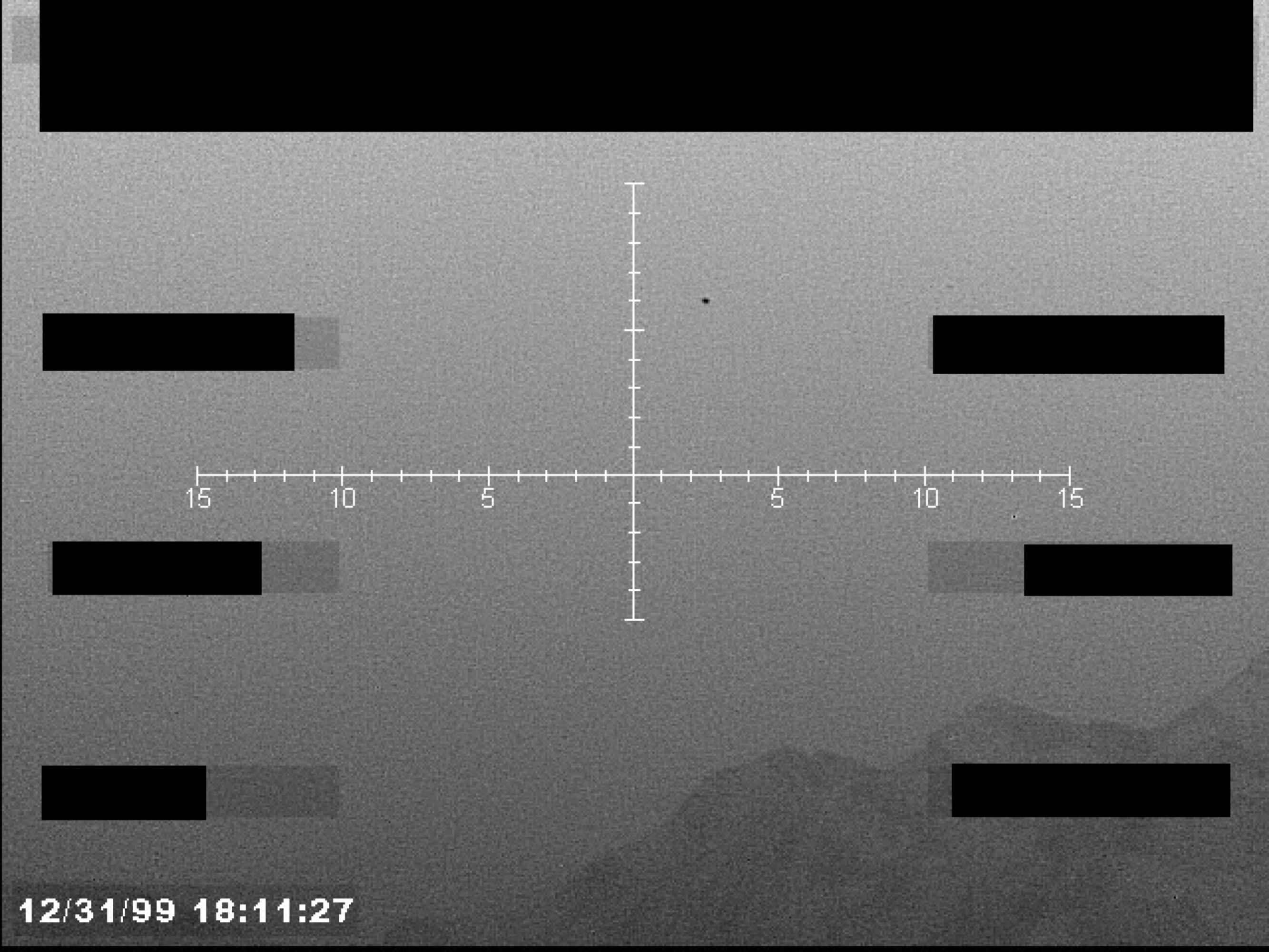 Sensor display with crosshairs, a small object near the center, and a timestamp. The background appears to be a mountainous or cloudy landscape.